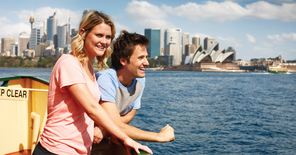 Woman and man cruising on a boat on Sydney Harbour