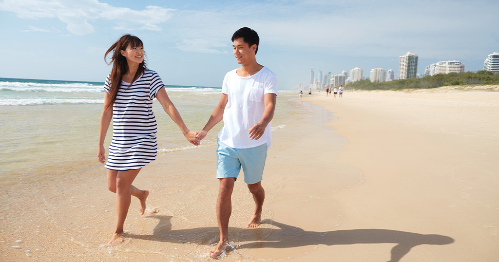 Woman and man walking on a beach in Gold Coast while holding hands