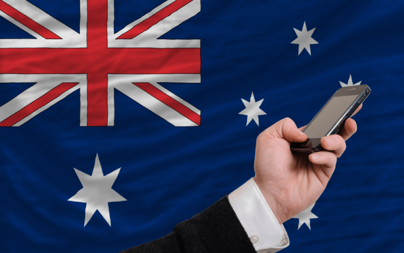 Holding cell phone in front of Australia flag